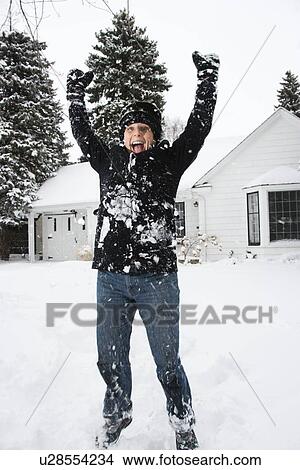 Caucasian mid adult woman jumping in air in snow. View Large Photo Image Picture - Caucasian mid adult woman jumping in air in snow.. Fotosearch