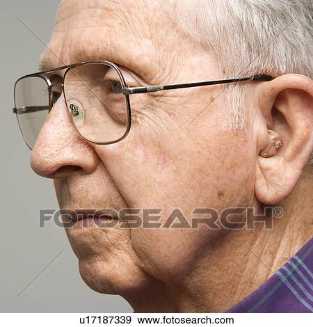 Close-up profile portrait of elderly man with glasses and hearing aid. View Large Photo Image Stock Photo - Close-up profile portrait of elderly man with glasses and hearing aid.. Fotosearch
