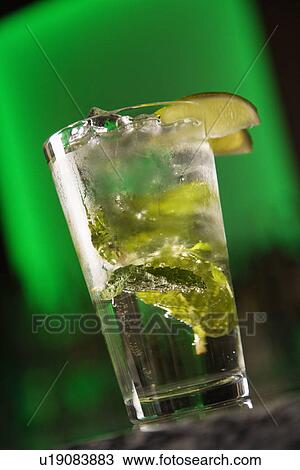 Cocktail with mint leaves and fruit garnish against glowing green background View Large Photo Image Stock Image - Cocktail with mint leaves and fruit garnish against glowing green background. Fotosearch