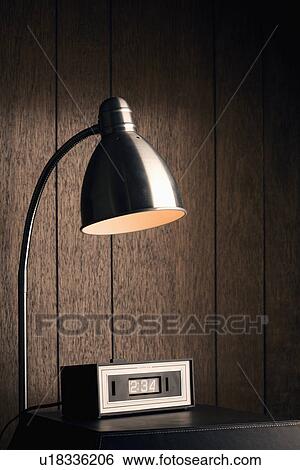 Desk lamp shining down on retro clock against wood paneling View Large Photo Image Stock Photograph - Desk lamp shining down on retro clock against wood paneling. Fotosearch
