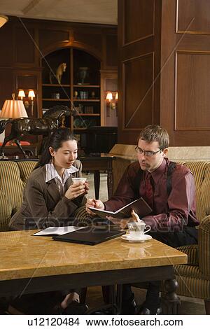 Drinking coffee and looking at portfolio View Large Photo Image Picture - Drinking coffee and looking at portfolio. Fotosearch