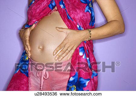 Stock Photograph - Expecting female with hands on stomach . Fotosearch