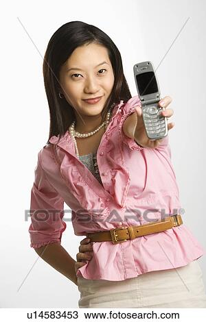 Female smiling and holding out cell phone View Large Photo Image Stock Image - Female smiling and holding out cell phone. Fotosearch