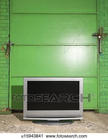 Flat panel television in front of green metal door View Large Photo Image Stock Image - Flat panel television in front of green metal door. Fotosearch