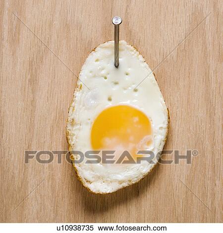 Fried egg nailed to wood. View Large Photo Image Stock Photography - Fried egg nailed to wood.. Fotosearch