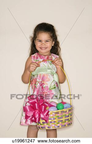 Stock Photo - Girl holding Easter basket smiling and looking at viewer. Fotosearch