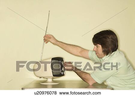 Man sitting at 50's retro dinette set adjusting old television antenna View Large Photo Image Stock Photo - Man sitting at 50's retro dinette set adjusting old television antenna. Fotosearch