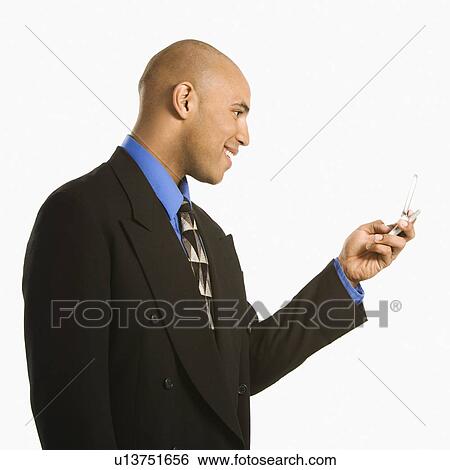 Man smiling and using cellphone View Large Photo Image Stock Photograph - Man smiling and using cellphone. Fotosearch