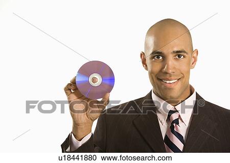 Stock Image - Man smiling holding out compact disc. Fotosearch
