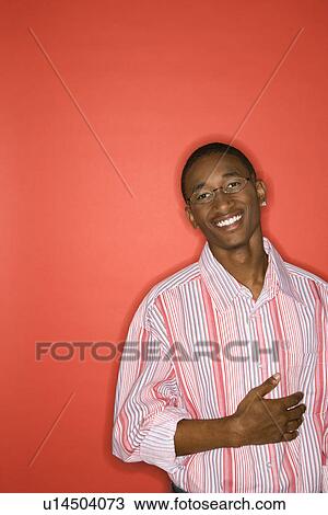 Man smiling with hand on abdomen standing against red background. View Large Photo Image Stock Image - Man smiling with hand on abdomen standing against red background.. Fotosearch