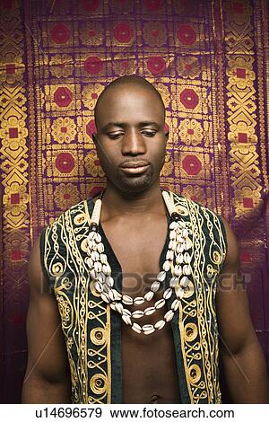 Stock Photo - Man wearing embroidered African vest and beads.. Fotosearch