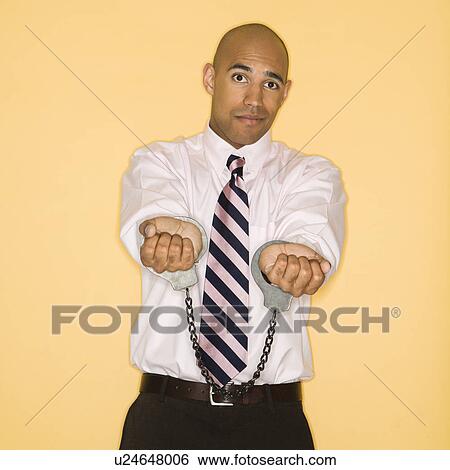 Man wearing handcuffs and looking sad View Large Photo Image Stock Photograph - Man wearing handcuffs and looking sad. Fotosearch