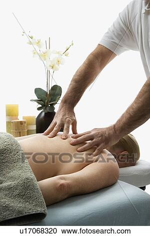 Massage therapist massaging back of woman lying on massage table View Large Photo Image Stock Image - Massage therapist massaging back of woman lying on massage table. Fotosearch