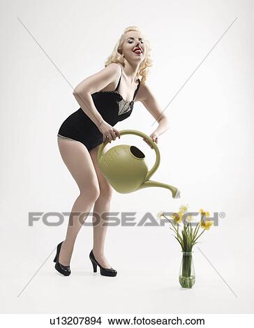 Pinup girl watering a vase of flowers View Large Photo Image Picture - Pinup girl watering a vase of flowers. Fotosearch