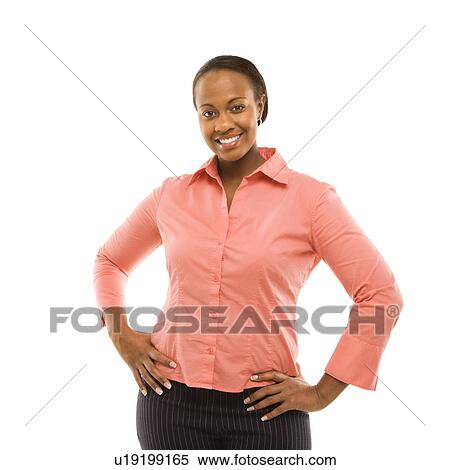 Stock Photography - Portrait of a woman standing and smiling against white background. Fotosearch