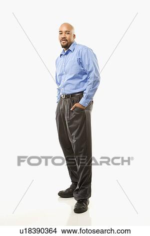 Picture - Portrait of African American man standing against white background.. Fotosearch
