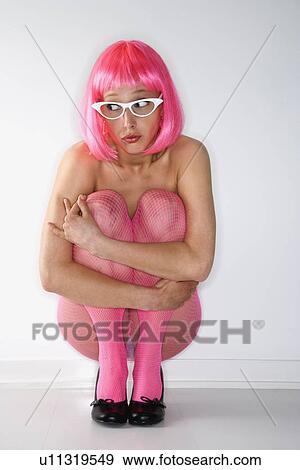 Portrait of attractive Caucasian young adult woman wearing pink wig and pink fishnet stockings, kneeling and hugging herself with anxious expression. View Large Photo Image Stock Photo - Portrait of attractive Caucasian young adult woman wearing pink wig and pink fishnet stockings, kneeling and hugging herself with anxious expression.. Fotosearch