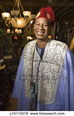 Stock Photograph - Portrait of smiling mid-adult man wearing traditional African clothing. Fotosearch