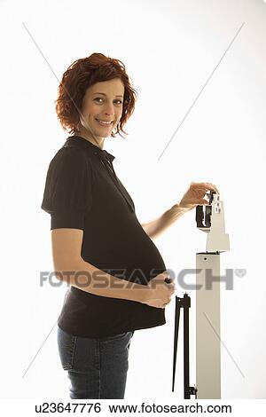 Stock Photograph - Pregnant woman standing on scale . Fotosearch