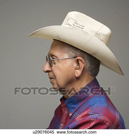 Stock Photography - Profile portrait of elderly man wearing plaid shirt and cowboy hat.. Fotosearch