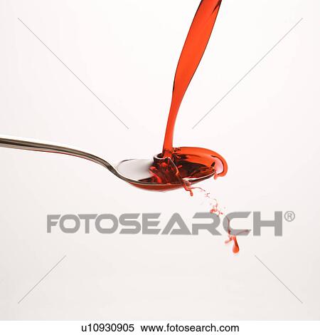 Stock Photography - red cough syrup splashing out of spoon. Fotosearch