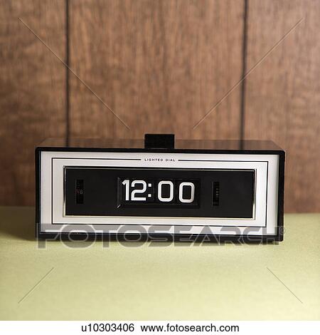 Stock Photograph - Retro clock set for 12: 00 against wood paneling.. Fotosearch