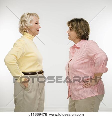 Stock Photograph - Senior woman and middle aged woman face to face arguing.. Fotosearch
