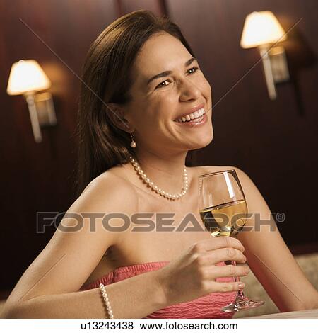 Stock Photo - Smiling woman in a dress holding a glass . Fotosearch