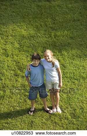 Stock Image - Standing on lawn with arms around each other. Fotosearch