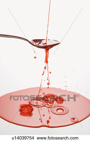 Picture - Stream of red cough syrup overflowing spoon into puddle below.. Fotosearch