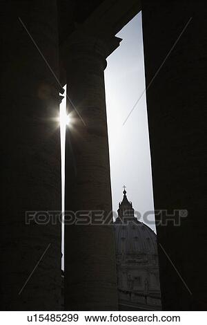 Stock Photo - Sun peeking through doric columns in Saint Peter's Square in Vatican City, Italy.. Fotosearch