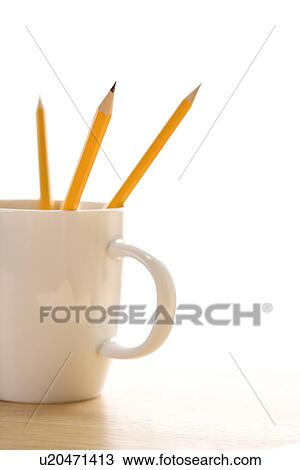 Stock Image - Three pencils in a coffee cup with pointed ends up. Fotosearch
