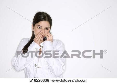 Whispering into cellphone standing View Large Photo Image Stock Photo - Whispering into cellphone standing . Fotosearch