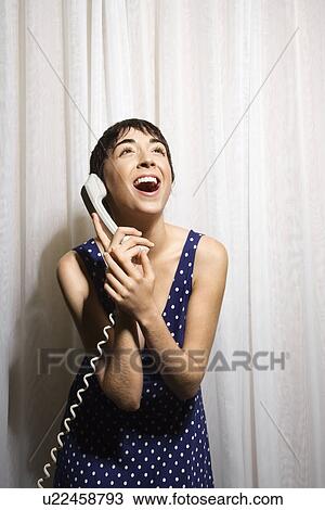 Woman holding telephone receiver to ear and laughing View Large Photo Image Stock Image - Woman holding telephone receiver to ear and laughing. Fotosearch