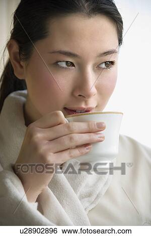 Stock Photograph - Woman in bathrobe drinking coffee. Fotosearch