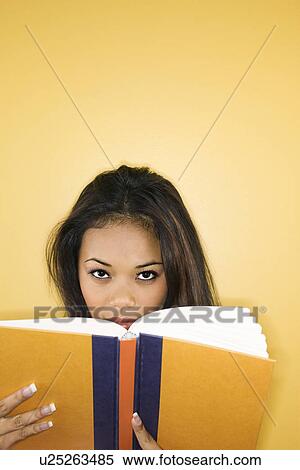 Stock Photography - Woman peering over book. Fotosearch