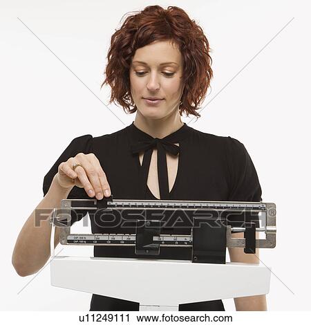 Woman reading her weight on scale View Large Photo Image Stock Image - Woman reading her weight on scale. Fotosearch