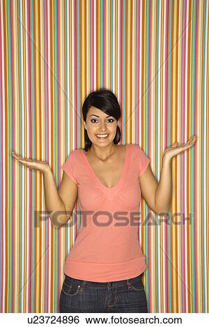 Woman shrugging on striped background View Large Photo Image Stock Photograph - Woman shrugging on striped background. Fotosearch