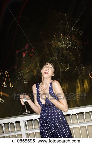 Woman smiling and drinking at night with blurred lights View Large Photo Image Stock Photography - Woman smiling and drinking at night with blurred lights. Fotosearch