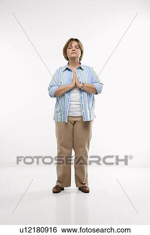 Stock Photograph - Woman standing while praying. Fotosearch