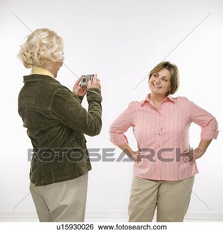 Stock Photograph - Woman taking photo of woman. Fotosearch