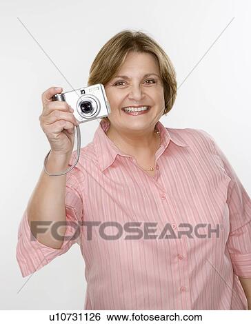 Stock Photograph - Woman taking photo with digital camera. Fotosearch