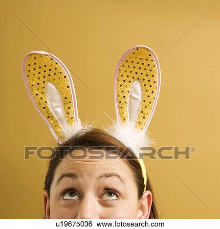 Woman wearing rabbit ears and looking up View Large Photo Image Stock Photograph - Woman wearing rabbit ears and looking up. Fotosearch