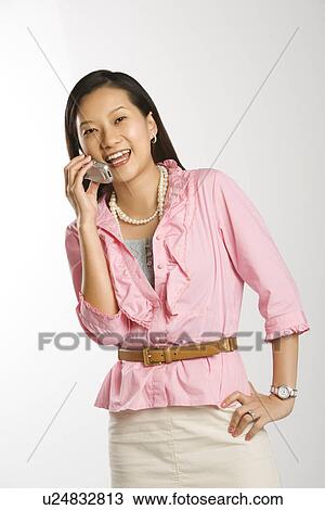 Woman with hand on hip smiling and talking on cell phone View Large Photo Image Stock Image - Woman with hand on hip smiling and talking on cell phone. Fotosearch
