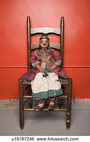 Wooden puppet sitting on chair View Large Photo Image Stock Photograph - Wooden puppet sitting on chair. Fotosearch