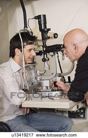 Optometrist examining patient View Large Photo Image Stock Photo - Optometrist examining patient. Fotosearch