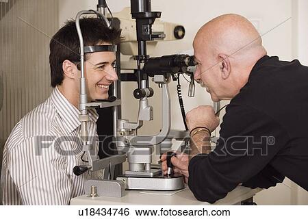 Optometrist examining patient View Large Photo Image Stock Photograph - Optometrist examining patient. Fotosearch