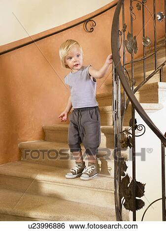 Stock Photograph - Little girl climbing down the stairs.. Fotosearch