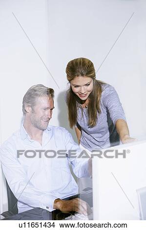 Picture - Man and woman in office at computer.. Fotosearch