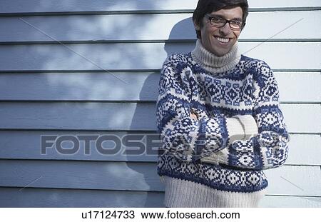 Stock Image - Young man wearing thick knitted sweater.. Fotosearch